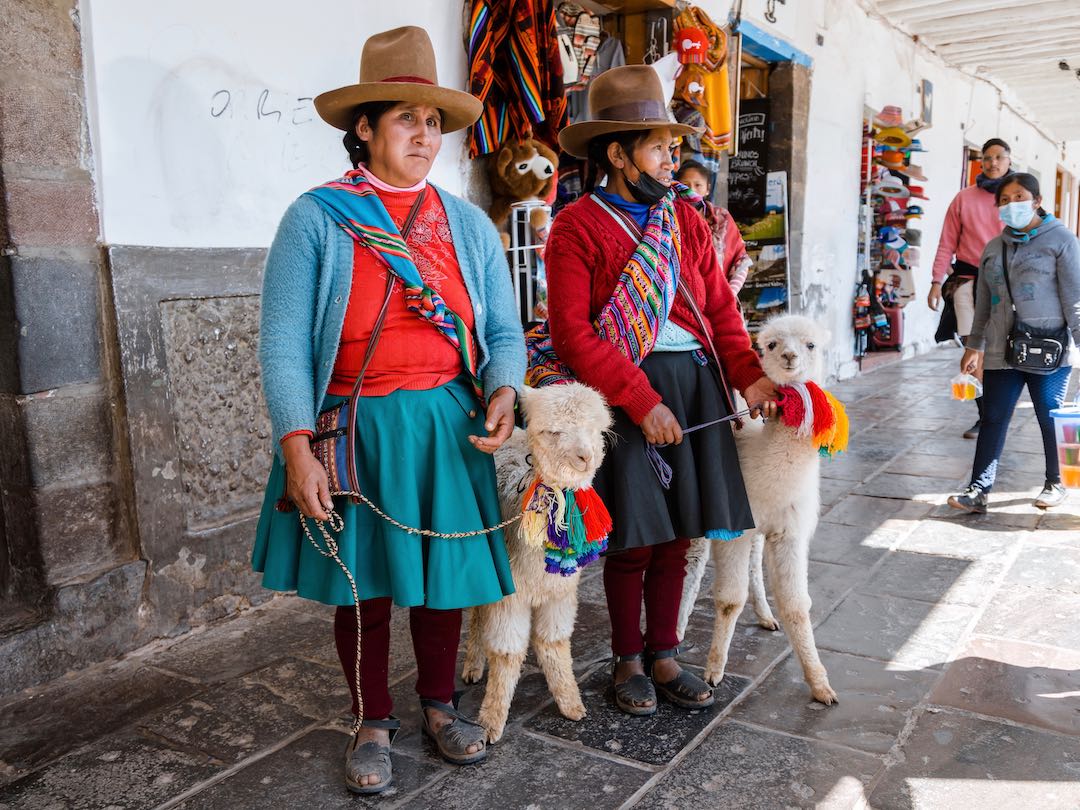 peru-group-tour-10-5 Ladies with traditional dress and Llamas in Peru