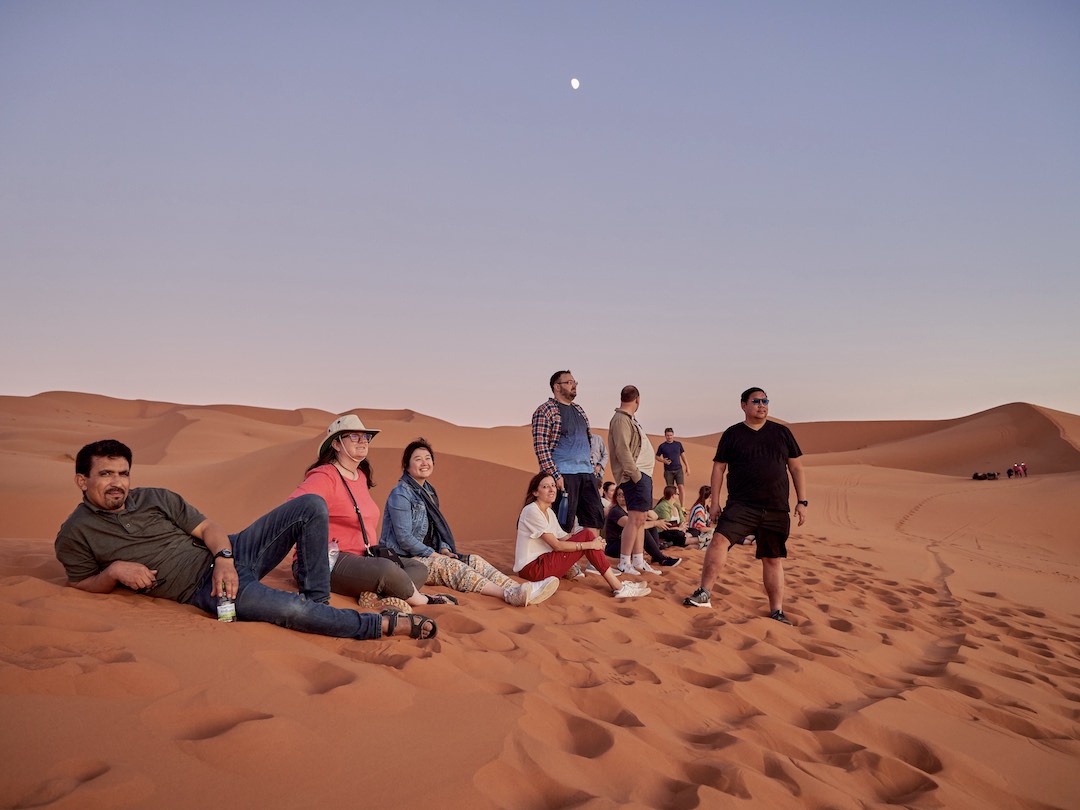 Watching sunset in the Sahara Desert during our Morocco group tour