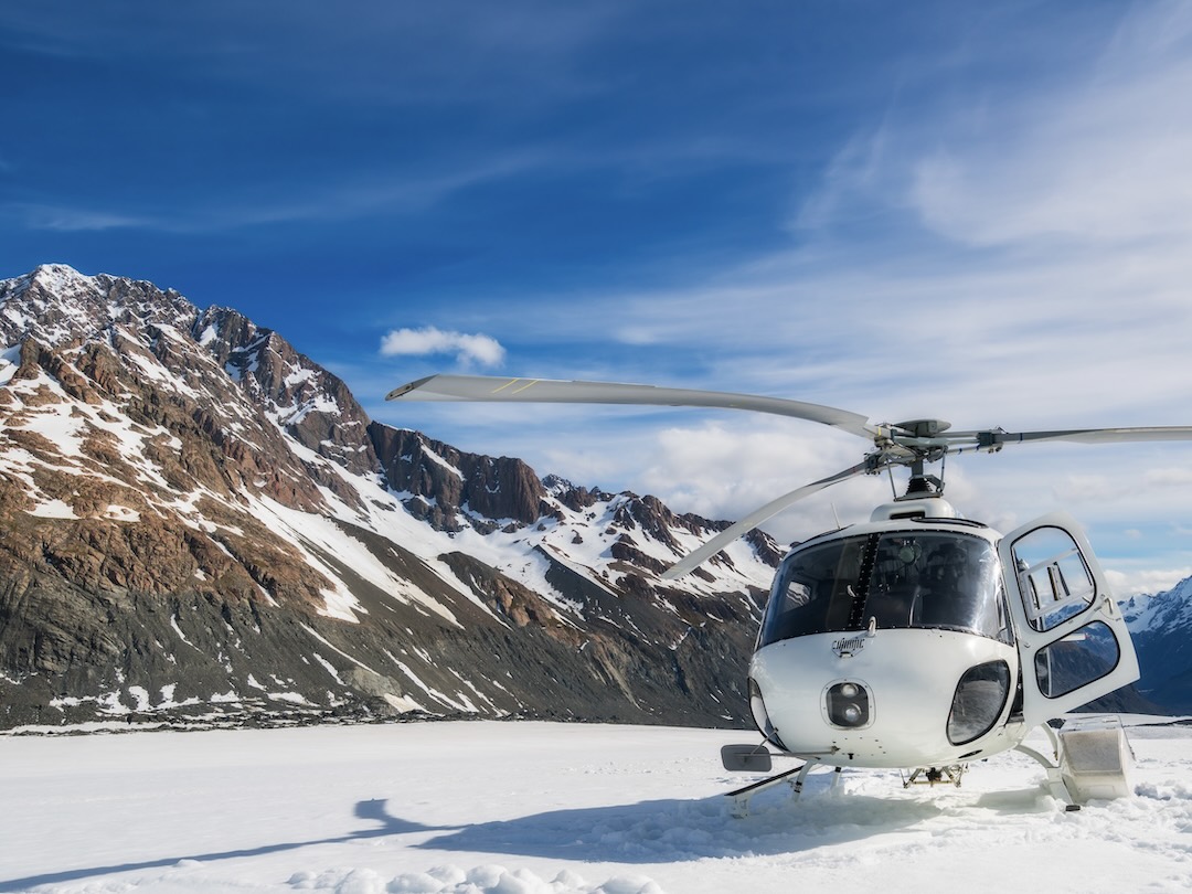 Helicopter landing on snow mountain in Tasman glacier in Mt Cook during the New Zealand group tour with Other Way Round Travel