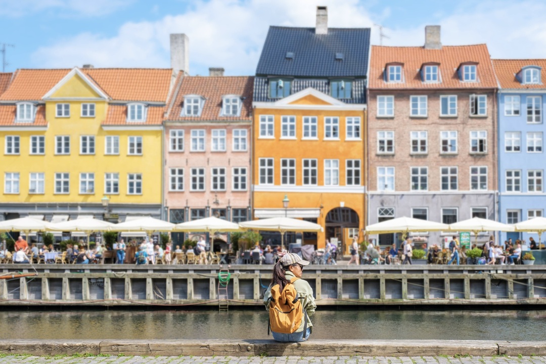 A lady enjoying Nyhavn, Copenhagen during the Other Way Round Travel group tour of Scandinavia